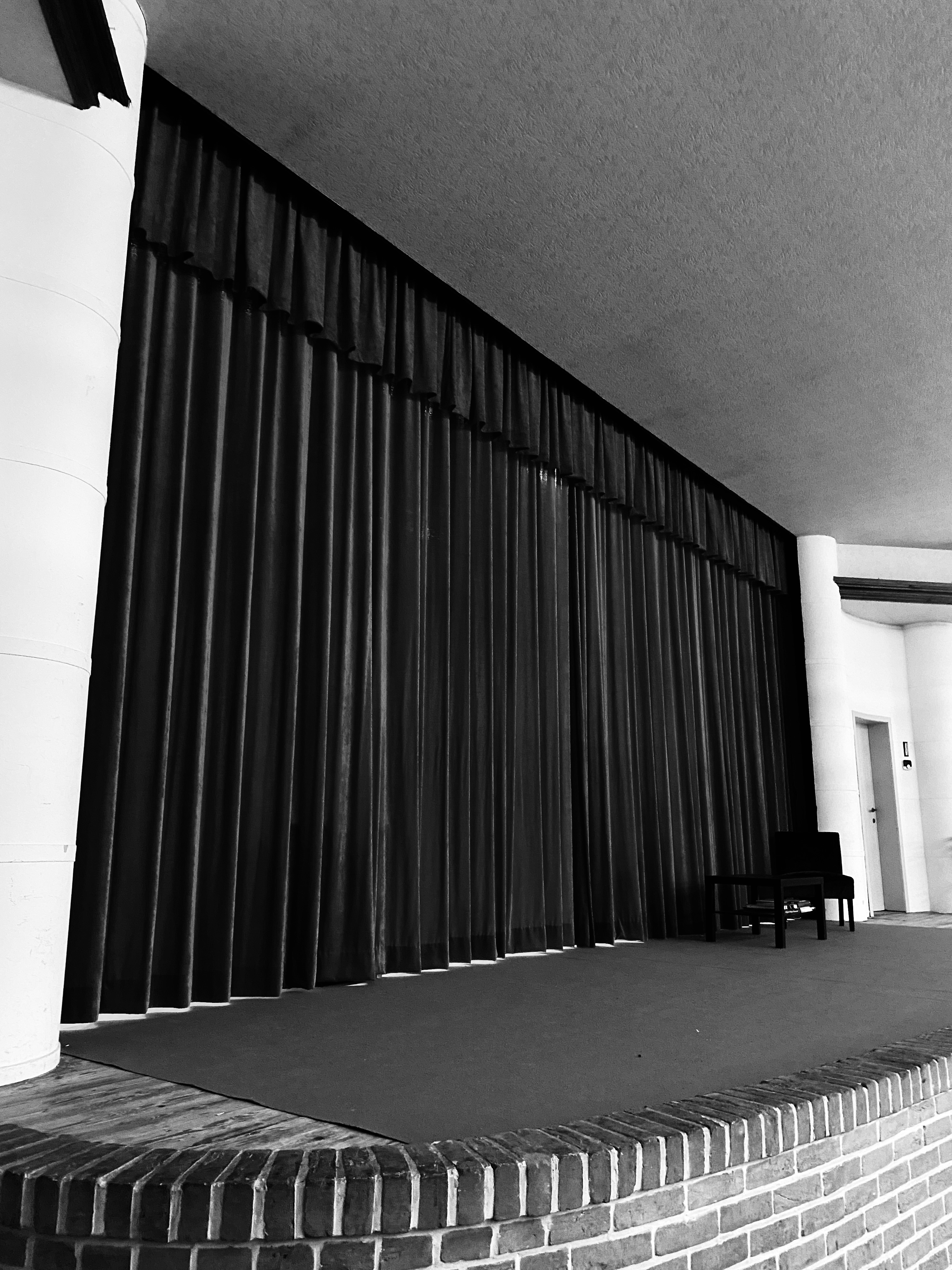Rood doek van podium dicht. Zwart wit filter hierop voor dramatisch effect